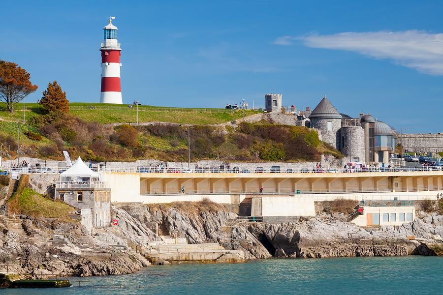 View of Plymouth Hoe with sea, benches, and lighthouse.